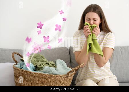 Giovane donna che annodava una lavanderia pulita a casa Foto Stock