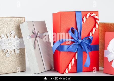 scatole regalo rosse e argentate con prua su sfondo bianco. Concetto di festa di Natale. Foto Stock