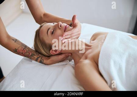 Bella donna che riceve massaggio alla schiena al salone di bellezza Foto Stock