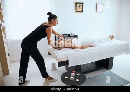 Fisioterapista professionista che effettua massaggi sulla sezione toracica nel resort termale Foto Stock