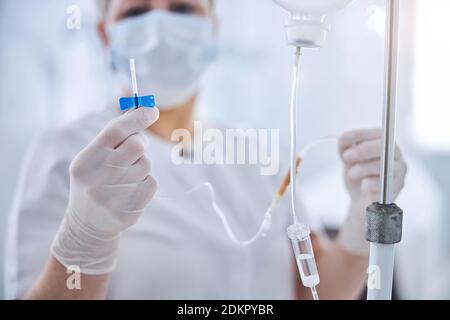 Medico femminile certificato con infusione endovenosa in clinica di medicina della mano Foto Stock