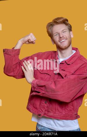 Giovane uomo dai capelli rossi con giacche rosse e un aspetto forte Foto Stock