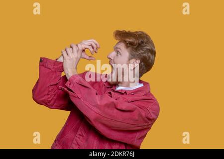 Ragazzo con i capelli rossi e bearded in giacca rossa divertendosi Foto Stock