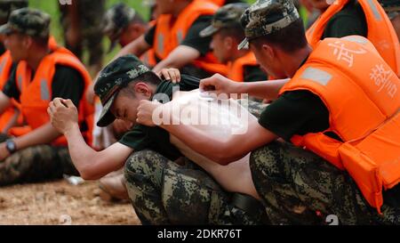 (201216) -- PECHINO, 16 dicembre 2020 (Xinhua) -- Rescuer applica le polveri sulla parte posteriore bruciata al sole del suo collega durante la rottura della missione di contenimento delle inondazioni al villaggio di Jiangjialing nella contea di Poyang, nella provincia di Jiangxi della Cina orientale, 11 luglio 2020. Guardando indietro a 2020, ci sono sempre alcune foto calde e momenti di contatto: La dedizione in prima linea nella lotta contro l'epidemia, la perseveranza sulla via dell'uscita dalla povertà, il coraggio di assumersi la responsabilità sull'argine contro l'alluvione, la gioia e l'orgoglio quando si raggiunge la vetta del Monte Qomolangma. Queste persone e cose Foto Stock