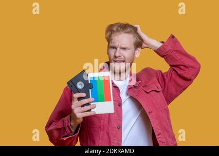 Giovane zenzero in giacca rossa con un aspetto da record perplesso Foto Stock