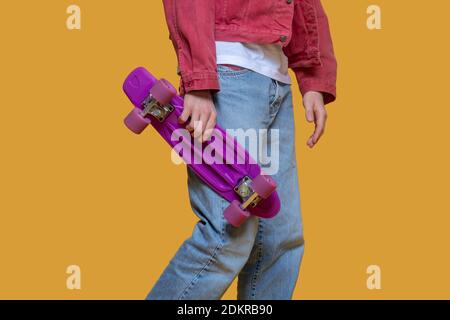 Uomo in giacca rossa con skateboard Foto Stock