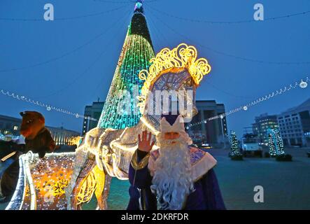 (201216) -- MINSK, 16 dicembre 2020 (Xinhua) -- un uomo vestito come Babbo Natale posa per le foto davanti alle decorazioni e alle luci di Natale a Minsk, Bielorussia, 15 dicembre 2020. (Foto di Henadz Zhinkov/Xinhua) Foto Stock