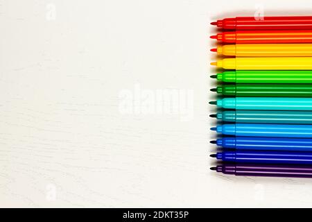 i pennarelli colorati senza tappi giacciono su un legno bianco tabella Foto Stock