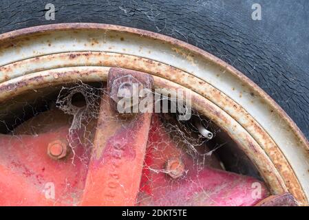 Un primo piano di una vecchia ruota del carrello usurata e pneumatico deperito (pneumatico) con ciottoli Foto Stock