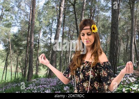 Teen Hippie ragazza medita all'aperto in una foresta Foto Stock