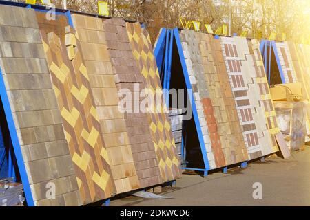 Piastrelle di pavimentazione in cantiere. Lastre per pavimentazione da magazzino per lavori di posa su strada. Costruzione di marciapiedi. Soleggiata. Foto Stock