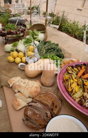 Un assortimento di cibi in ciotole su un tavolo a buffet durante un evento serale Foto Stock