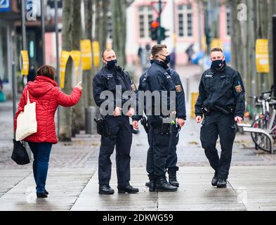 Magonza, Germania. 16 Dic 2020. Gli ufficiali di polizia parlano con un passanti su Ludwigtraße. La polizia sta attualmente effettuando controlli mascherati. A causa della chiusura a livello nazionale, numerose aziende rimangono chiuse. La presenza obbligatoria nelle scuole viene revocata. Credit: Andreas Arnold/dpa/Alamy Live News Foto Stock