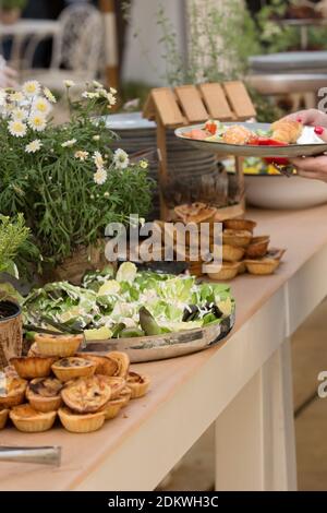 Un assortimento di cibi in ciotole su un tavolo a buffet durante una elegante reception Foto Stock