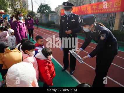 Nanjing, provincia cinese di Jiangsu. 16 Dic 2020. I poliziotti introducono la conoscenza dei treni ad alta velocità in un asilo durante un'attività per contribuire a migliorare la sicurezza del traffico dei bambini e la consapevolezza dell'auto-protezione a Nanjing, nella provincia di Jiangsu, nella Cina orientale, il 16 dicembre 2020. Credit: Ji Chunpeng/Xinhua/Alamy Live News Foto Stock