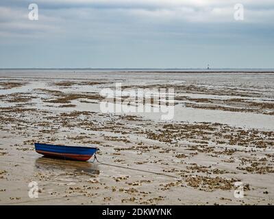 Barca da pesca nel Mare del Nord a bassa marea vicino alla città Wilhelmshaven, Wadden Sea National Park, Germania Foto Stock