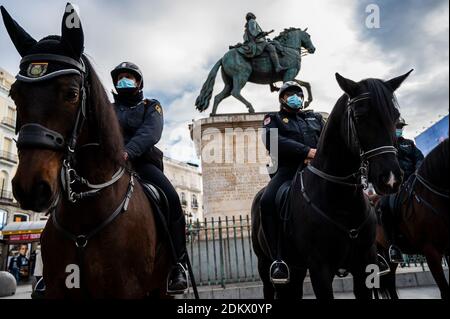 Madrid, Spagna. 16 Dic 2020. Polizia montata con maschere di protezione pattuglia in Piazza Sol durante la presentazione del dispiegamento della polizia per la sicurezza durante le celebrazioni di Natale. Quest'anno la polizia dovrà anche monitorare che le misure di sicurezza e di restrizione contro il coronavirus diffuso (COVID-19) sono realizzate. Credit: Marcos del Mazo/Alamy Live News Foto Stock