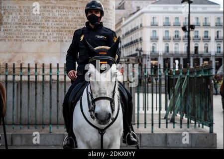 Madrid, Spagna. 16 Dic 2020. Ufficiale di polizia montato indossando una maschera di pattuglia in Piazza Sol durante la presentazione del dispiegamento della polizia per la sicurezza durante le celebrazioni di Natale. Quest'anno la polizia dovrà anche monitorare che le misure di sicurezza e di restrizione contro il coronavirus diffuso (COVID-19) sono realizzate. Credit: Marcos del Mazo/Alamy Live News Foto Stock