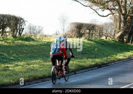 Una bicicletta in tandem cavalcata su una strada di campagna in inverno, Warwickshire, Inghilterra, Regno Unito Foto Stock