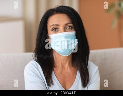 Ritratto di donna matura che indossa una maschera monouso per prevenire le infezioni Foto Stock