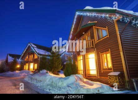 Casa di montagna nella neve durante la notte Foto Stock