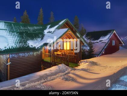 Casa di montagna nella neve durante la notte Foto Stock