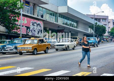 Donna cubana jaywalking a la Rampa, l'Avana, Cuba Foto Stock