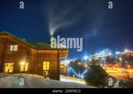 Casa di montagna nella neve durante la notte Foto Stock