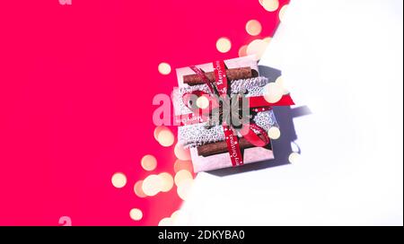 Regalo di Natale o regalo con nastro rosso isolato su sfondo bianco e rosso. Disposizione piatta, vista dall'alto con concetto di shopping natalizio dello spazio per la copia. Foto Stock