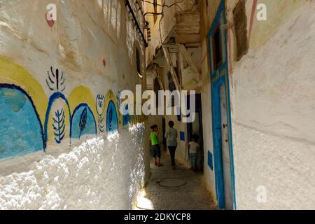 Bambini che giocano in uno stretto passaggio vicino al cimitero ebraico nel quartiere ebraico (Mellah) di Fes, Marocco. Foto Stock