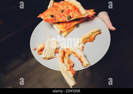 Poche fette di pizza hawaiana mangiata a metà, composizione Foto Stock