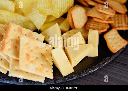 Mix di diversi spuntini e antipasti. Piatto Street food con set di vari tipi di snack: Cracker di pane piccante, patatine fritte e salsa, pomodori, delic Foto Stock