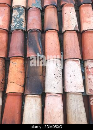 Vecchie tegole multicolore nei colori arancio, rosso, rosa e grigio. Schema di sfondo astratto di colore testurizzato sul tetto Foto Stock