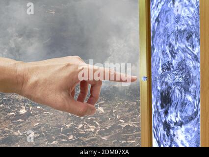 dito che punta sulla goccia d'acqua nel telaio di vetro con wildfire e sfondo di fumo Foto Stock