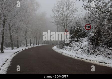 Un pericoloso tratto di strada su una mattina invernale nebbiosa. Foto Stock