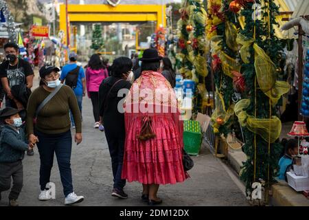 La Paz, Bolivia. 15 Dic 2020. Le persone che indossano maschere camminano attraverso il mercato di Natale, che è stato permesso di rimanere aperto nonostante la pandemia di Corona. Secondo i dati ufficiali, 147,345 persone sono state infettate da Covid-19 in Bolivia a livello nazionale. Il tasso di mortalità ufficiale è del 6.12%. Il governo di la Paz sta considerando misure anti-corona più severe a causa di un aumento del numero di persone infette. Credit: Radoslaw Czajkowski/dpa/Alamy Live News Foto Stock