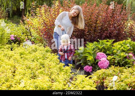 Madre insegna al figlio di camminare in giardino Foto Stock