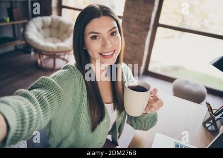 Ritratto di ragazza ottimista che fa caffè di bevanda selfie da casa indossare una camicia verde all'interno Foto Stock