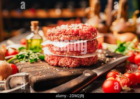 Polpettine di manzo in porzionato con macinato rotondo, a base di carne di manzo macinata Preparato per su un piatto.hamburger di carne condita e pronta per Un barbecue.Speices e co Foto Stock