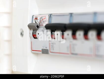 Dettaglio di un interruttore in una scatola fusibili domestica. Utilità elettrica domestica. Sistema automatico di sicurezza e risparmio di vita Foto Stock