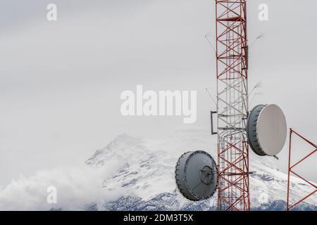 Antenne di comunicazione sulla cresta delle Ande sopra Papallacta in Ecuador. Con il vulcano Antisana innevato sullo sfondo. Foto Stock