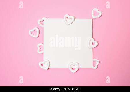 Scena di San Valentino o di nozze mockup con carta bianca, carta cuori confetti, spazio vuoto per il tuo testo, vista dall'alto. Foto Stock