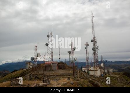 Antenne di comunicazione sulla cresta delle Ande sopra Papallacta in Ecuador. Con il vulcano Antisana innevato sullo sfondo. Foto Stock