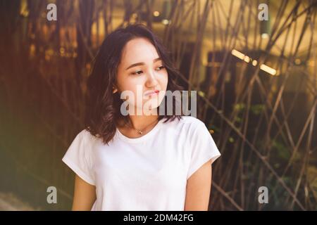 Giovane donna asiatica in una camicia bianca, portrat di strada Foto Stock