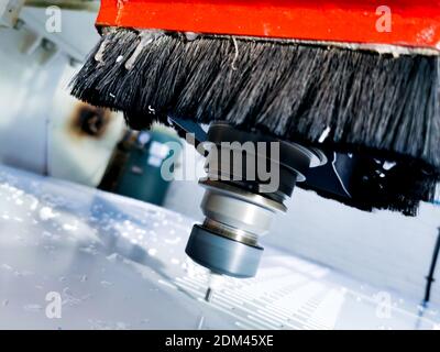 Vista generale di una macchina CNC che taglia un pannello di polietilene in uno stabilimento di produzione di materie plastiche. Foto Stock