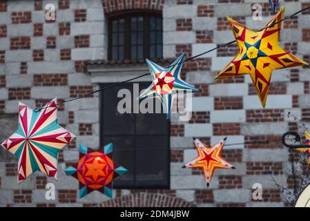 Lublino, Polonia - 29 dicembre 2019: Colorate stelle illuminate come decorazioni natalizie con porta di Cracovia (Brama Krakowska) come sfondo Foto Stock