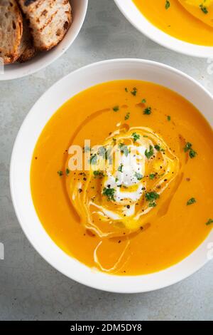 Zuppa di zucca servita in una ciotola con crostini, prezzemolo e olio d'oliva. Foto Stock