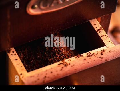 Macinacaffè d'epoca, in tonalità scure su rustico sfondo in legno. Vecchia attrezzatura per la preparazione del caffè. Messa a fuoco selettiva. Profondità di campo poco profonda. Foto Stock