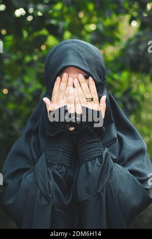 Asian Muslim girl, Portrait of happy beautiful young woman religious wear veil hijab she sad crying using hand wiping tears in her eyes. Stock Photo