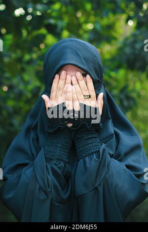 Asian Muslim girl, Portrait of happy beautiful young woman religious wear veil hijab she sad crying using hand wiping tears in her eyes. Stock Photo